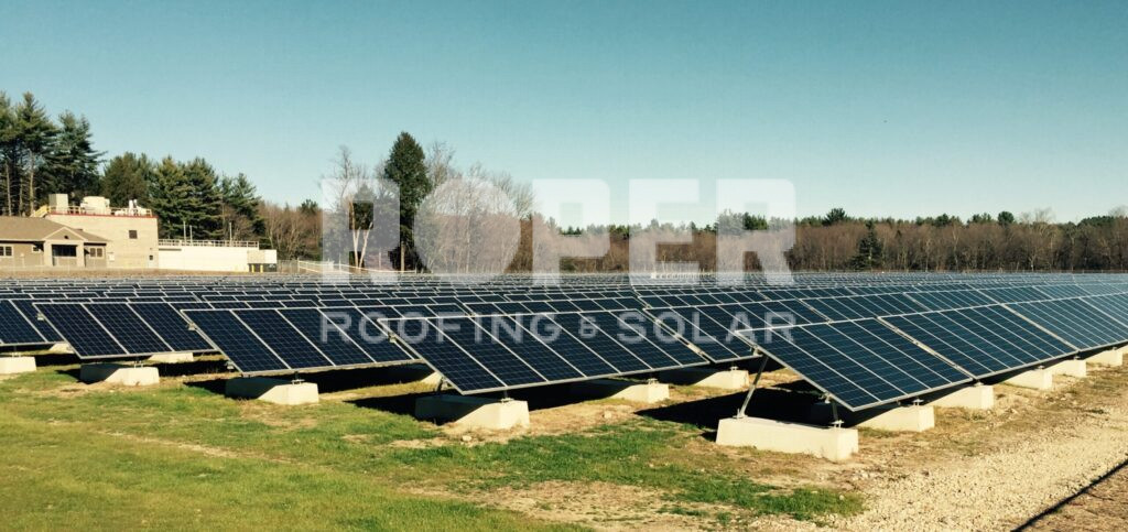 Large solar panel farm with rows of photovoltaic panels on concrete foundations