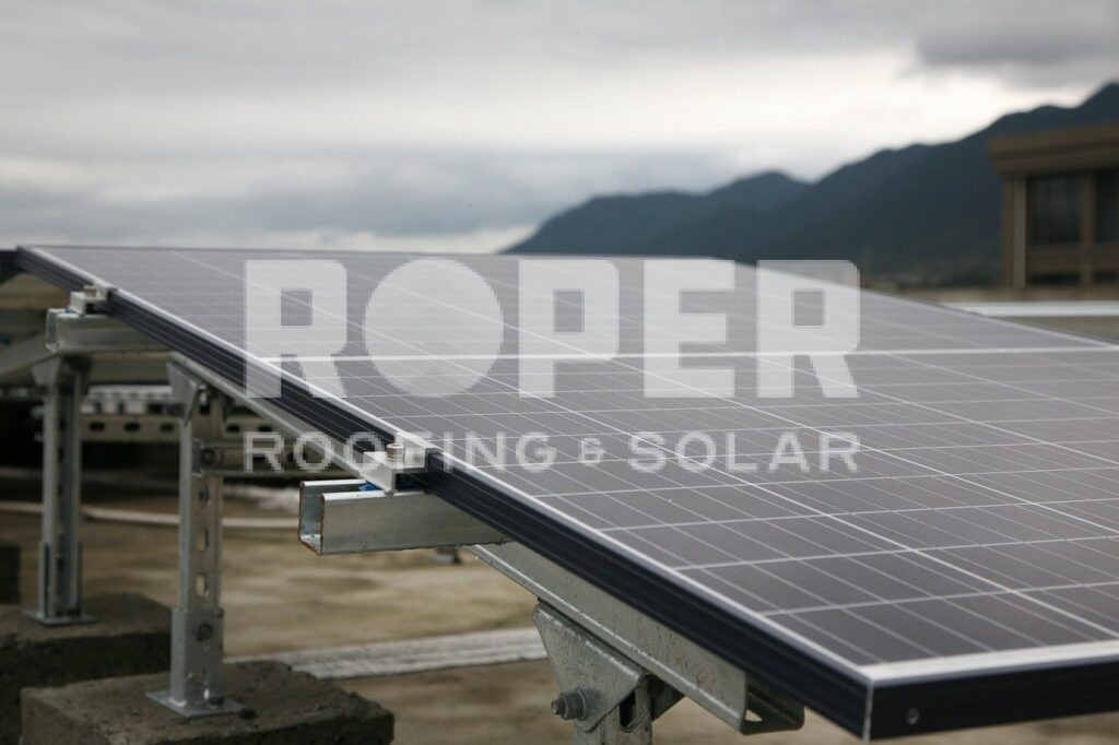 Solar panels mounted on metal frames in mountainous landscape under cloudy sky