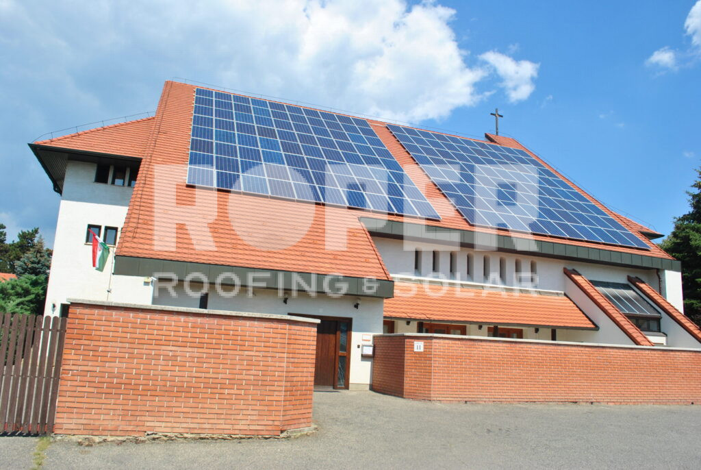 Modern residential home with solar panels on red tile roof and brick exterior
