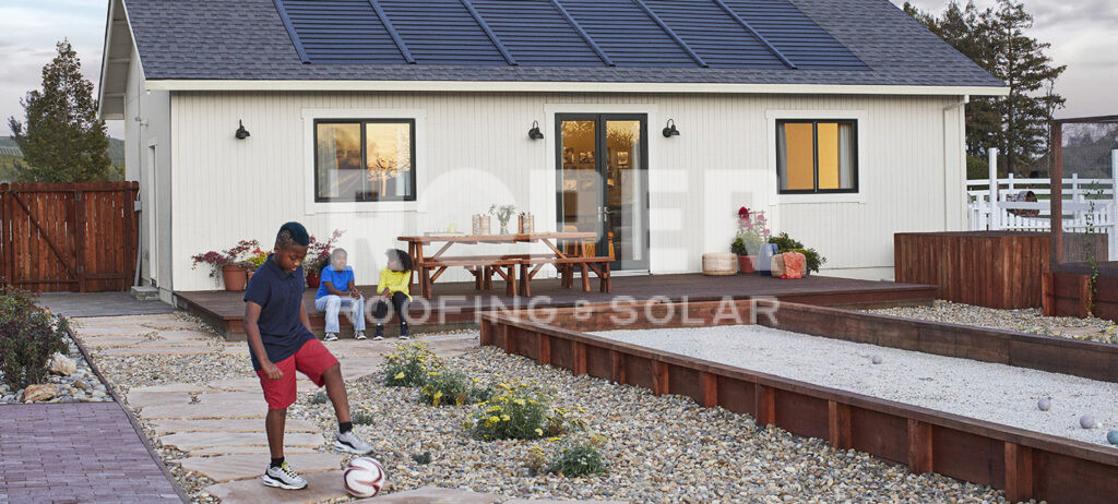Modern white farmhouse with solar panels and family playing in landscaped backyard