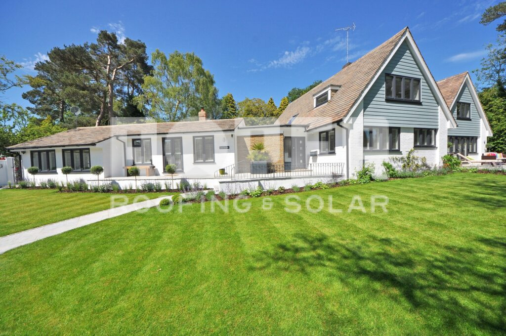 Modern white house with gray shutters and large landscaped lawn on sunny day