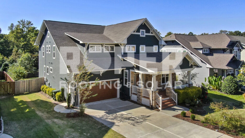 Modern two-story suburban home with gray and navy siding, stone accents, and garage