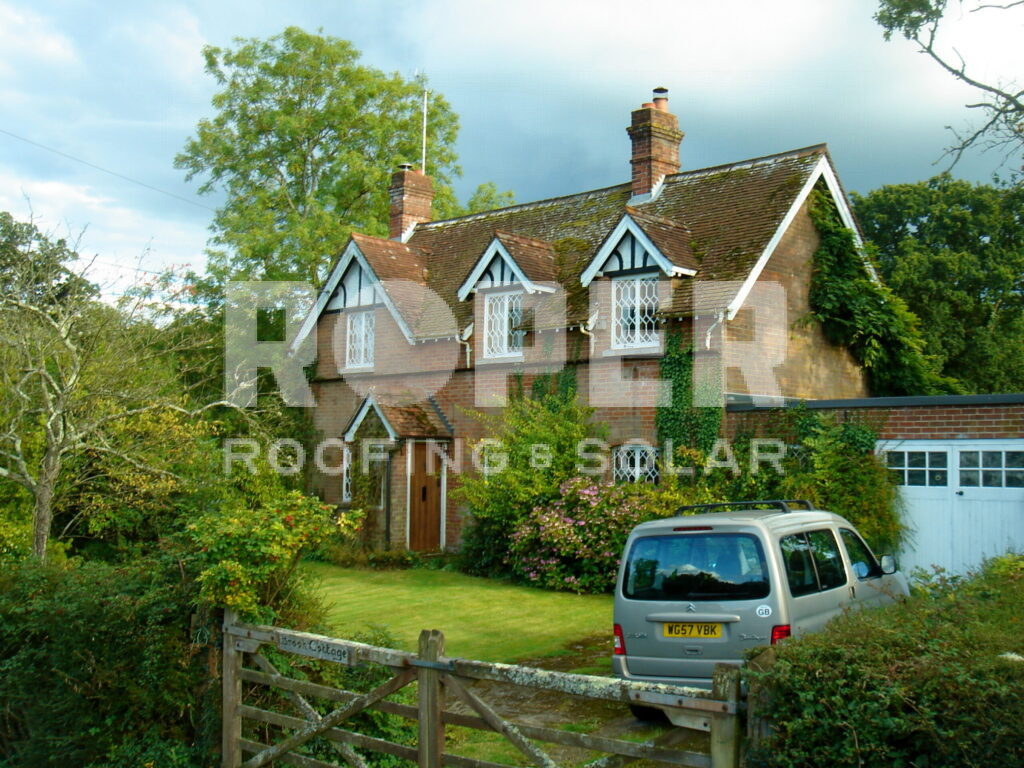 Traditional English cottage with Tudor-style gables and brick chimneys in countryside