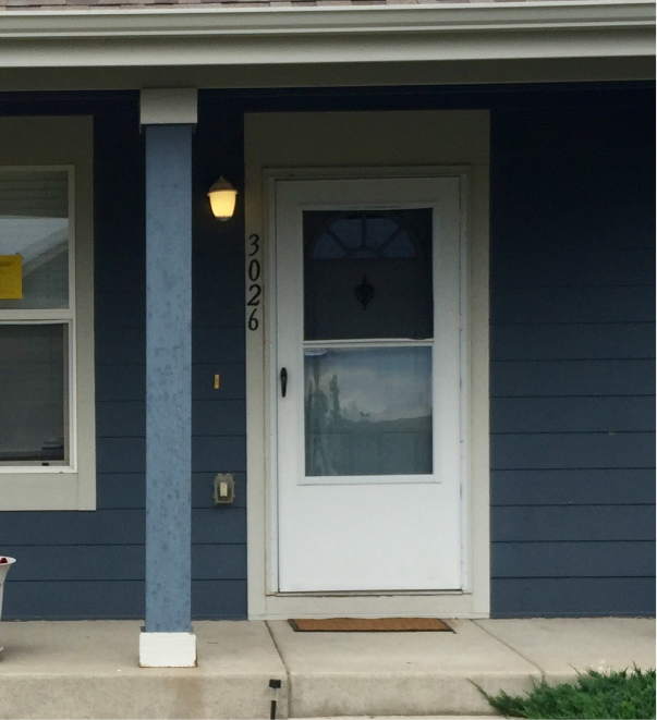 Blue house front door entrance with white door, address number 3026, and porch