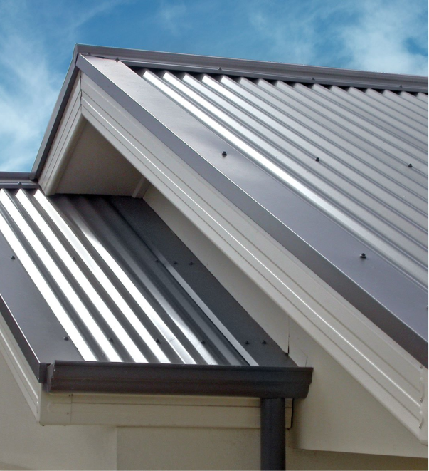 Modern house with corrugated metal roofing and white trim against blue sky