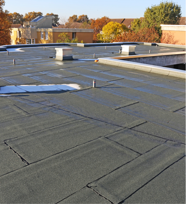 Flat commercial roof with rubber membrane and ventilation units in autumn setting
