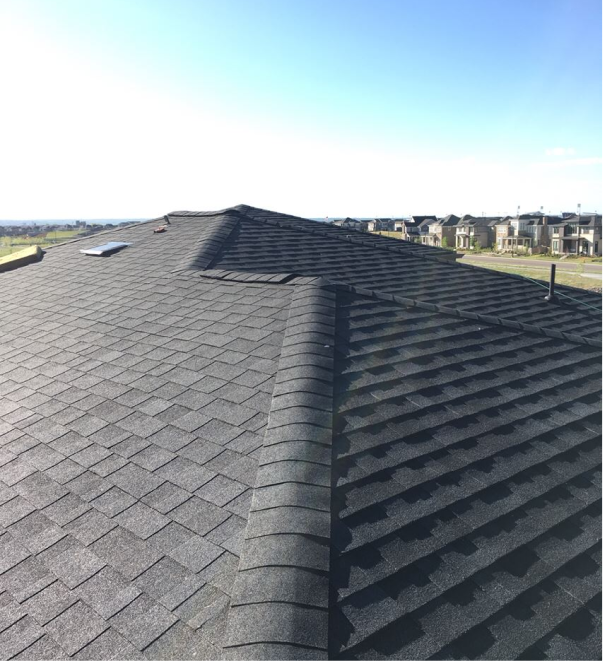 Dark gray asphalt shingle roof with ridge line view from residential home rooftop