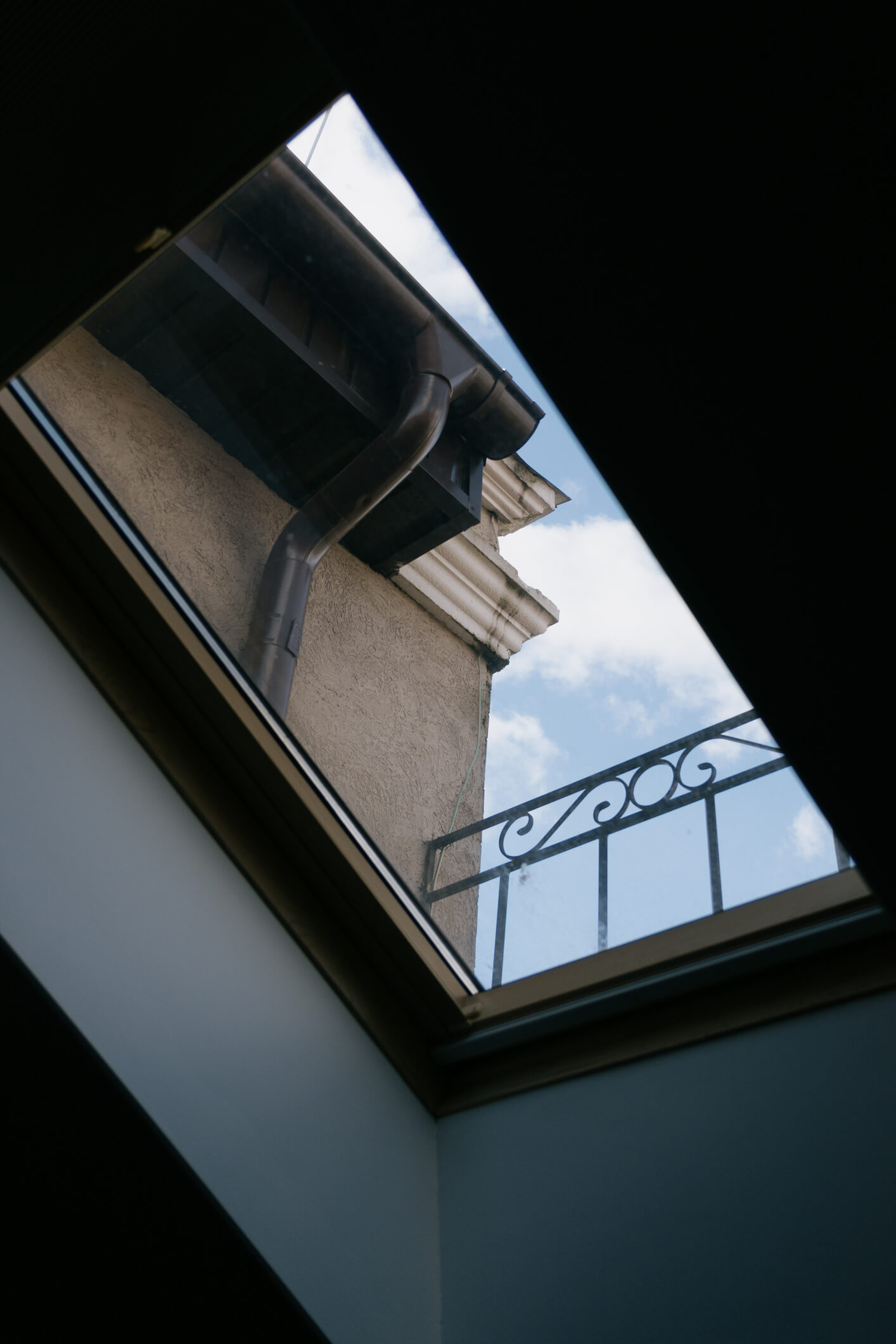 Open skylight window showing view of classic building with decorative balcony railing