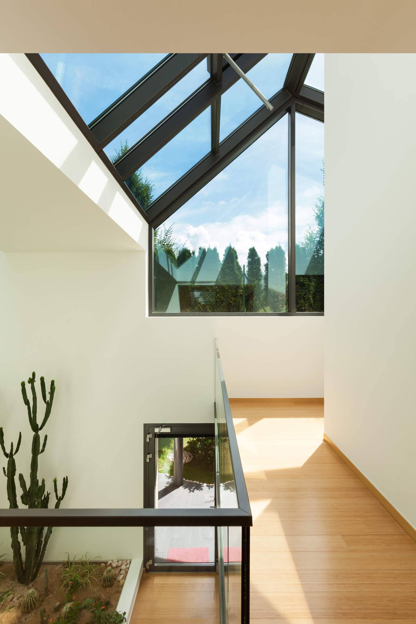 Modern home interior with glass ceiling skylight and wooden stairs