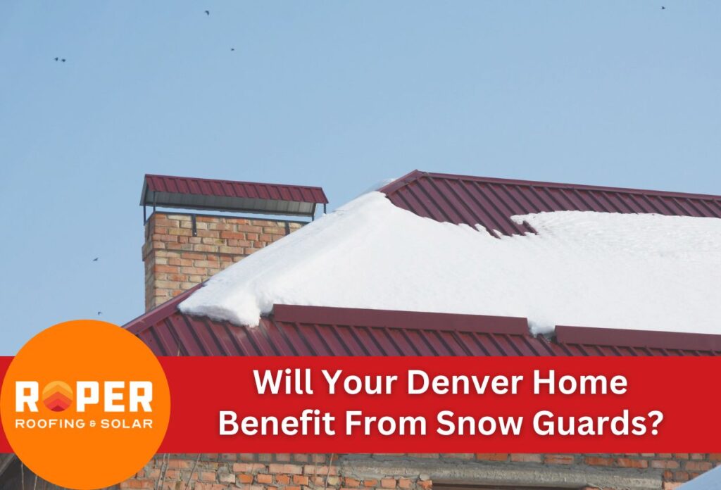 Snow-covered red metal roof with brick chimney showing need for snow guards