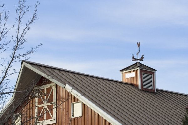 brown metal roof with wind vane on top