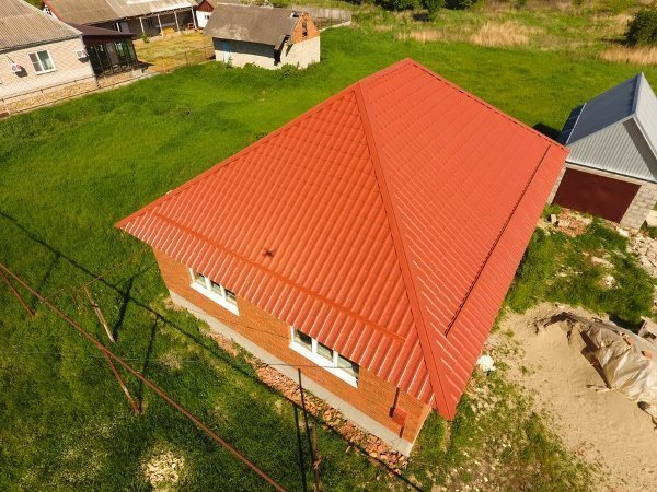 dark orange hipped roof of one story house with orange walls