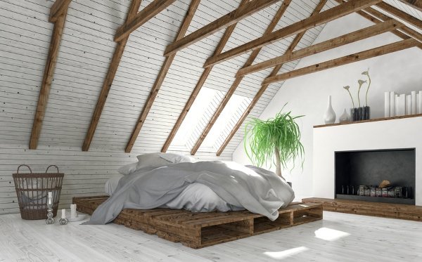 white and clean attic room with bed and fireplace