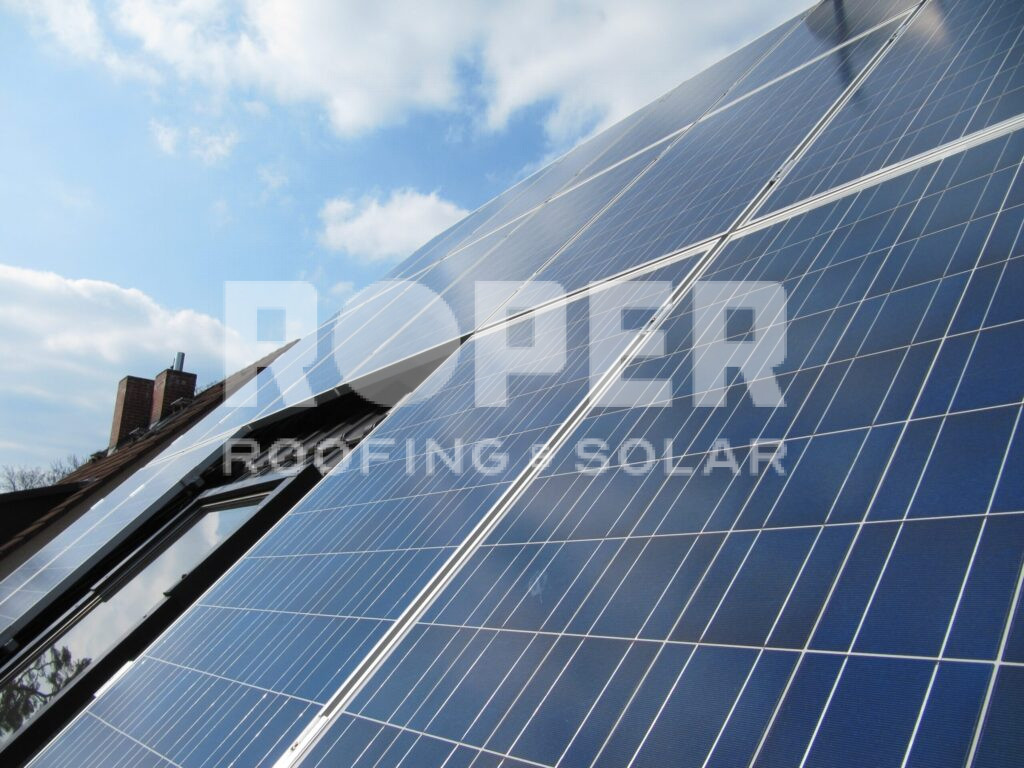 Solar panels on residential rooftop against blue cloudy sky for renewable energy
